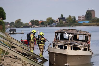 İtfaiye Hollandsche IJssel 'deki bir yatta tamamen yangınla meşgul. Çelik duvarı geçmek için kobra kesici kullanıyorlar.