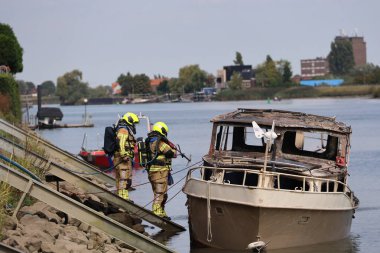 İtfaiye Hollandsche IJssel 'deki bir yatta tamamen yangınla meşgul. Çelik duvarı geçmek için kobra kesici kullanıyorlar.