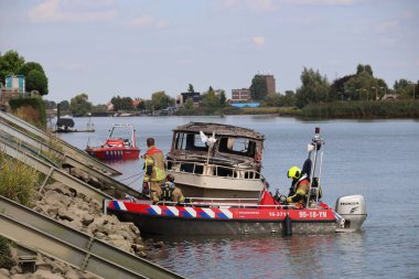 İtfaiye Hollandsche IJssel 'deki bir yatta tamamen yangınla meşgul. Çelik duvarı geçmek için kobra kesici kullanıyorlar.