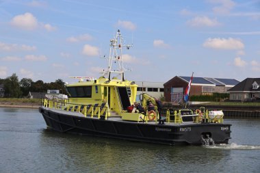 İtfaiye, Hollandsche IJssel 'de bir yatta Rijkswaterstaat teknesinin asistanıyla dolu.