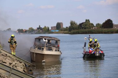 İtfaiye, Hollandsche IJssel 'de itfaiye teknelerinin kullanıldığı bir yat dolusu ateşe tutulmuş durumda.