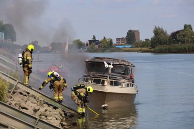 İtfaiye Hollandsche IJssel 'deki bir yatta tamamen yangınla meşgul.
