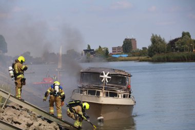 İtfaiye Hollandsche IJssel 'deki bir yatta tamamen yangınla meşgul.