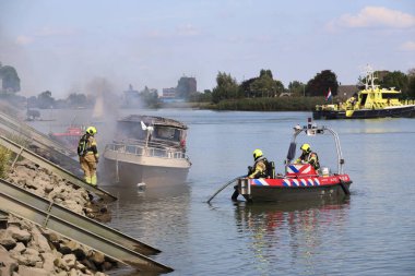 İtfaiye, Hollandsche IJssel 'de itfaiye teknelerinin kullanıldığı bir yat dolusu ateşe tutulmuş durumda.