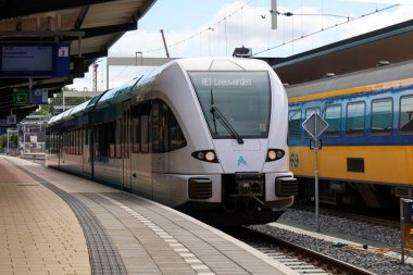 Stadler bölgesel banliyö treni Hollanda 'daki Groningen tren istasyonunda Arriva platformu boyunca ilerliyor.