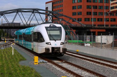 Stadler bölgesel banliyö treni Hollanda 'daki Groningen tren istasyonunda Arriva platformu boyunca ilerliyor.