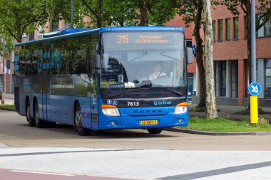 Blue Qliner hızlı Qbuzz otobüsü Heerenveen İstasyonu Hollanda 'daki Frisian Provence Friesland' a doğru koşuyor.