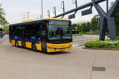 Sarı Qbuzz otobüsü Hollanda 'daki Leeuwarden İstasyonu' nda Frizya Kaynağı 'na doğru koşuyor.