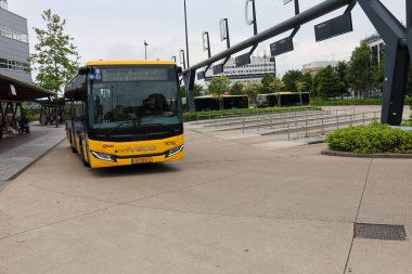 Sarı Qbuzz otobüsü Hollanda 'daki Leeuwarden İstasyonu' nda Frizya Kaynağı 'na doğru koşuyor.