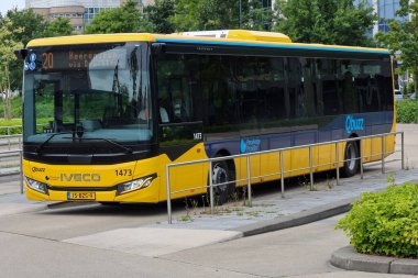 Sarı Qbuzz otobüsü Hollanda 'daki Leeuwarden İstasyonu' nda Frizya Kaynağı 'na doğru koşuyor.