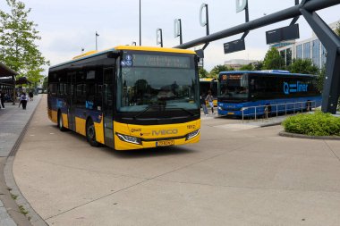 Sarı Qbuzz otobüsü Hollanda 'daki Leeuwarden İstasyonu' nda Frizya Kaynağı 'na doğru koşuyor.
