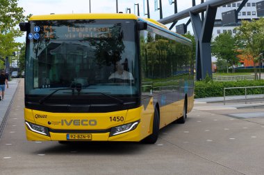 Sarı Qbuzz otobüsü Hollanda 'daki Leeuwarden İstasyonu' nda Frizya Kaynağı 'na doğru koşuyor.