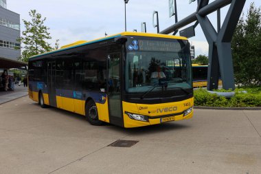 Sarı Qbuzz otobüsü Hollanda 'daki Leeuwarden İstasyonu' nda Frizya Kaynağı 'na doğru koşuyor.