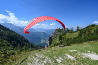 Bir paraglider, güneşli bir günde Jenner Dağı 'nın yakınında Koenigssee Gölü' nde havalanıyor.