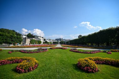Güneşli bir günde Salzburg 'un arka planında Hohensalzburg kalesi olan Garden Mirabell