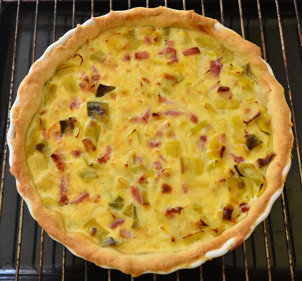 Een Franse prei taart met gerookte spekreepjes — Stockfoto