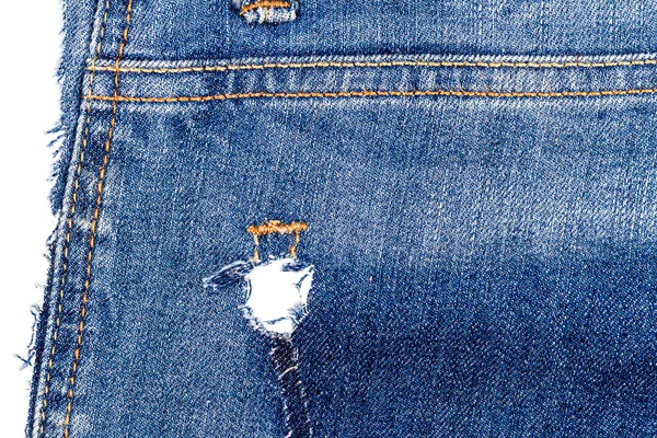 Piece of blue jeans fabric with a ripped of back pocket isolated on white background. Rough uneven edges. Denim fabric torn.