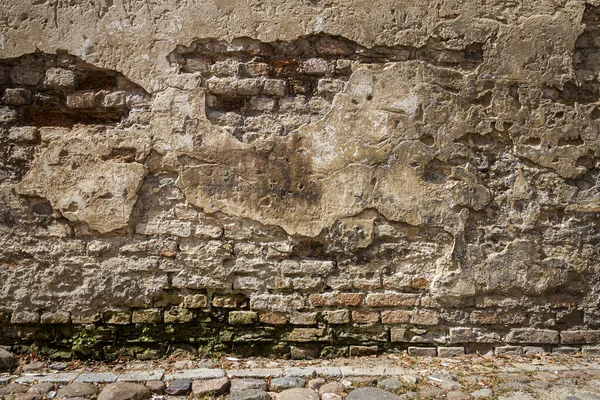 旧的风化砖墙和鹅卵石 — 图库照片