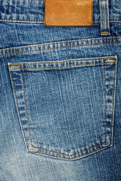 Tecido de jeans azul com bolso e etiqueta — Fotografia de Stock