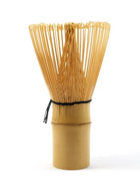 Beyaz arka planda izole edilmiş matcha çayı hazırlamak için geleneksel bambu çırpıcı kullanılır.