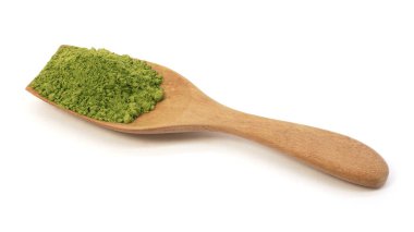 Beyaz arka planda izole edilmiş ahşap kaşıkta kibrit yeşil çay tozu