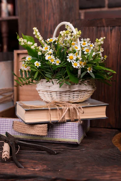 Chamomile decor composition with books and box on the brown wood table