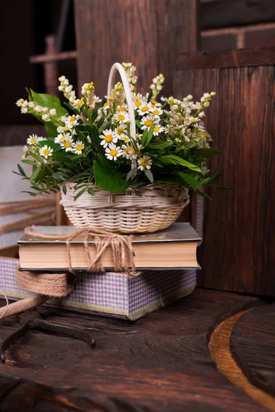 Chamomile decor composition with books and box on the brown wood table