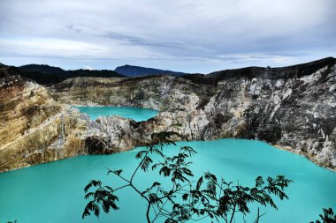 Flores 'teki Kelimutu Gölü Ulusal Parkı' ndaki bir volkan kraterindeki çok renkli güzel bir volkanik gölün fotografı muhteşem bir gökyüzünün arka planına karşı.