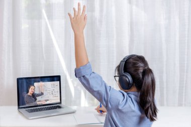 Asyalı küçük kız öğrenci internetten öğreniyor. Okul öğretmeninden öğreniyor. Covid-19 salgını. Adam beyaz tahtayla matematik öğretiyor. Ev okulundan ev konseptinden öğreniyorum.