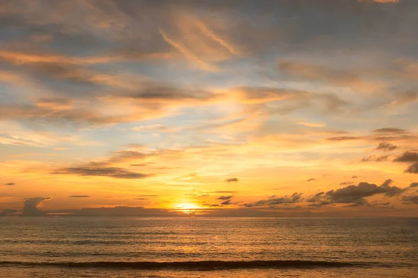 Deniz kabuğu üzerinde bulutlu ve gökyüzü arkaplanlı güzel bir gün batımı. Tropik sahilde gün batımı. Doğal yaz konsepti. Sarı ışıkla günbatımının zirvesi bulutları yansıtır.