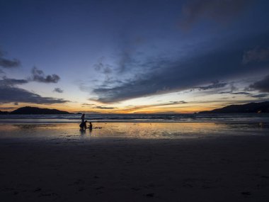 Deniz kabuğunun üzerinde bulutlu arka planda güzel bir gün batımı. Tropik sahilde gün batımı. Doğal yaz konsepti. Sarı ışıkla günbatımının zirvesi deniz suyunu yansıtır. Huzurlu deniz manzarası. Suyun üzerinde ufuk..