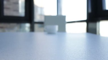 Masadaki bir adam beyaz bir fincandan çay ya da kahve içiyor.