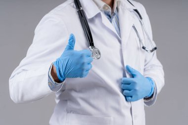 Önlüklü ve steteskoplu doktor gri arka planda izole edilmiş gibi görünüyor. Seçici odaklanma. Sağlık hizmeti konsepti. Kesilmiş fotoğraf.