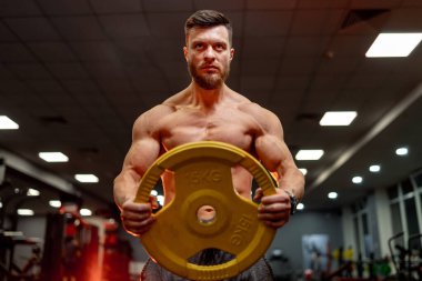 Ön manzara. Adam spor salonunda antrenman yapıyor. Çubuk için krep egzersizi yapıyorum..