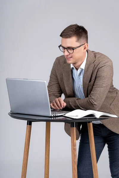 Affärsman Med Laptop Skrivbordet Guy Kostym Isolerad Över Grå Bakgrund — Stockfoto