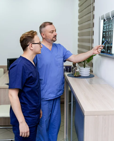 Orvosok Egy Beteg Röntgenjét Vizsgálják Férfi Radiológusok Állnak Megvilágított Tábla — Stock Fotó