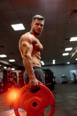 Adam spor salonunda antrenman yapıyor. Çubuk için sarı kreple egzersiz yapıyorum. Seçici odak.