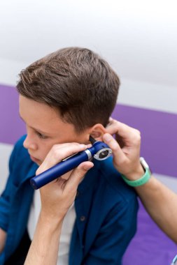 Doktor hastanede özel ekipmanlı bir çocuğun kulaklarını kontrol ediyor. Tıbbi kontrol..