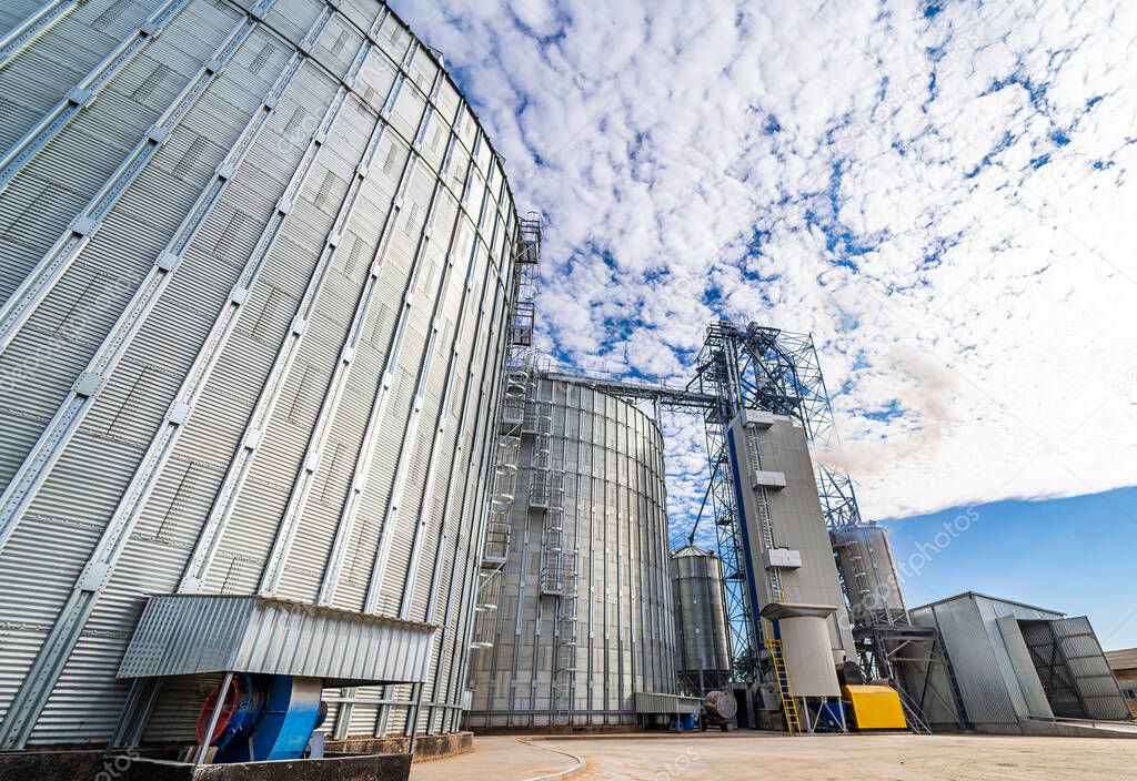 A metal grain facility with silos. Agricultural plant in rural zone. Modern steel equipment.