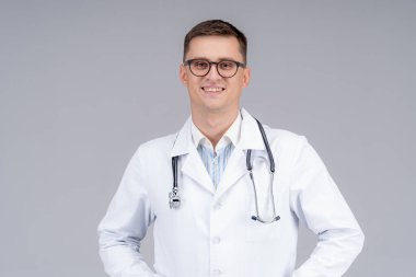 Beyaz önlüklü doktor ve boynunda fonendoskop neşeyle gülümsüyor. Mavi lastik eldivenli doktor. Stüdyo fotoşoplama.