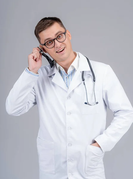 Önlüklü Yakışıklı Doktor Kulağına Fonendoskop Dayadı Komik Duygular — Stok fotoğraf