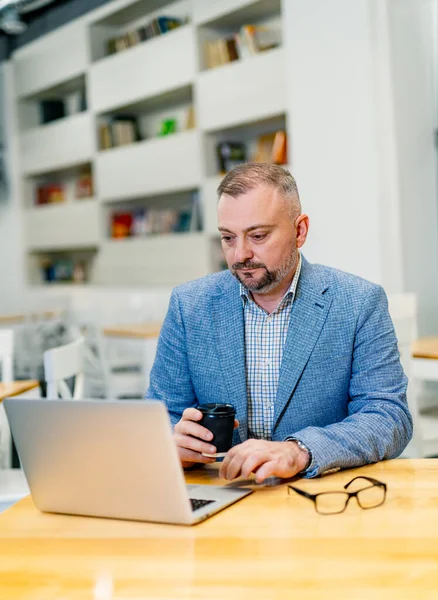 Przystojny Dojrzały Biznesmen Pracujący Laptopie Nowoczesne Tło Biurowe — Zdjęcie stockowe