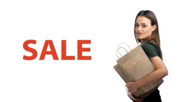 Kadının elinde beyaz arka planda alışveriş torbası var. Güzel bir kızın elinde açık kahverengi bir kese kağıdı. İzole edilmiş arka plan. Satış başlığı.