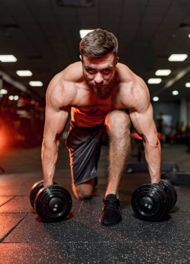 Güçlü atletik adamlar kaslarını şişiriyor. Spor malzemeleriyle egzersiz yapıyorum. Vücut geliştirici spor salonunda çıplak bedenle egzersiz yapıyor. Fitness ve vücut geliştirme konsepti.