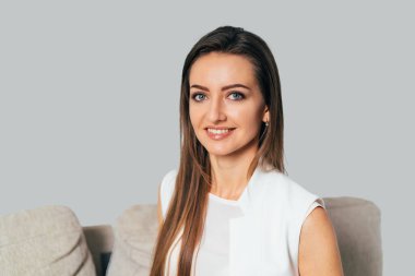 Zarif beyaz gömlekli güzel bir kadının portresi. Siyah saçlı çekici bir bayan..