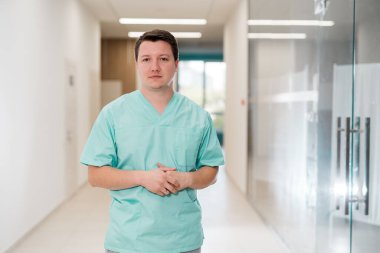 Tıbbi bir klinikte poz veren üniformalı bir doktor. Önlüklü doktor..