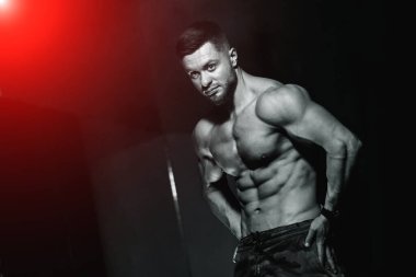 Mükemmel karın kasları olan mükemmel bir vücut. Çıplak gövdeli sporcu kameraya poz veriyor. Siyah beyaz fotoğraf.