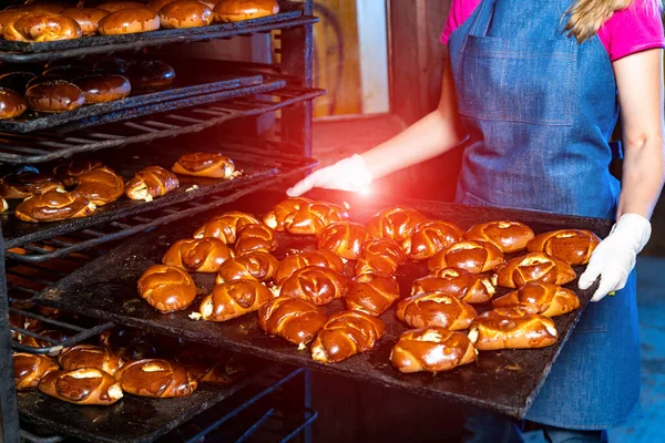 Production line of baking cookies. Racks with pastry. Woman with tray at factory. Closeup.