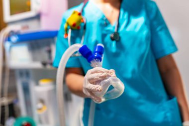 Mavi önlüklü tanınmayan doktor hastanede anestezi ve canlandırma için oksijen maskesi tutuyor. Seçici odak.