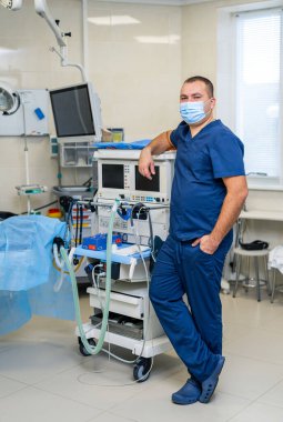 Hastanedeki ameliyathanede bir cerrah. Sıhhiye ekipman geçmişi için ayakta.